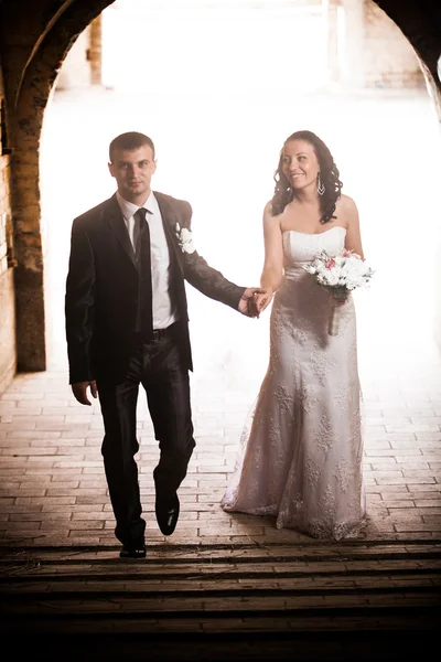 这对新婚的夫妇在古代石拱桥下走 — 图库照片
