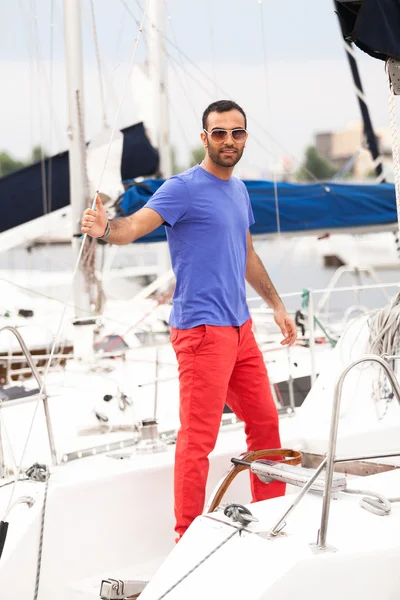Portrait of sexy man standing on white yacht — Stock Photo, Image