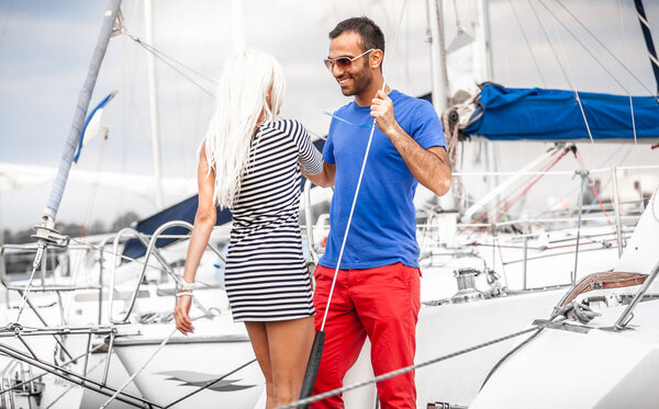 Latin man inviting sexy blonde woman on his yacht