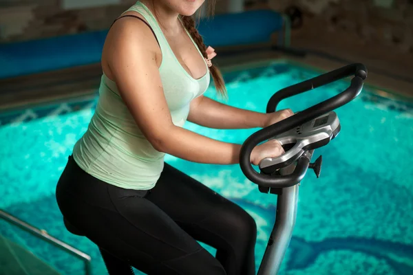 Підійде дівчина їзда на гімнастичному велосипеді в басейні — стокове фото