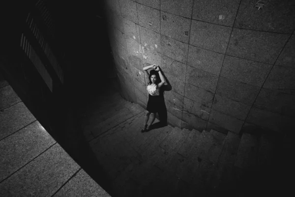 Photo de femme brune appuyée contre un mur de pierre — Photo