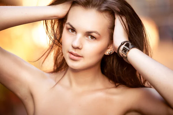 Beautiful brunette girl lifting up hair at street — Stock Photo, Image