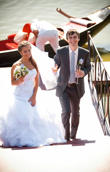 Супружеская пара, идущая по пирсу против гондолы — стоковое фото