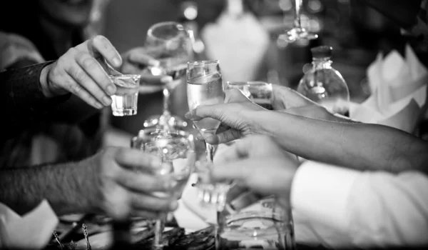 Photo of hands clinking glasses with vodka at party Stock Picture