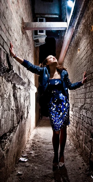 Femme en robe bleue posant entre deux murs de briques — Photo