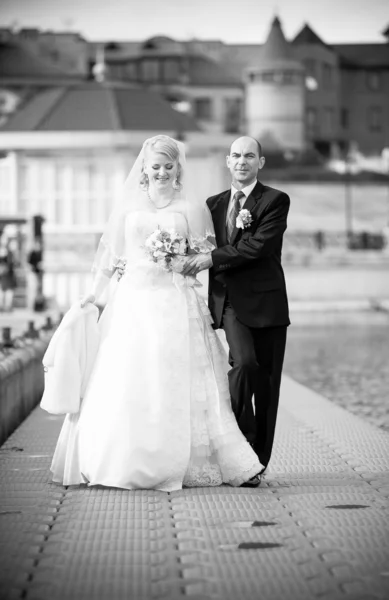 Shot of adult bride and groom walking on pier — Stock Photo, Image