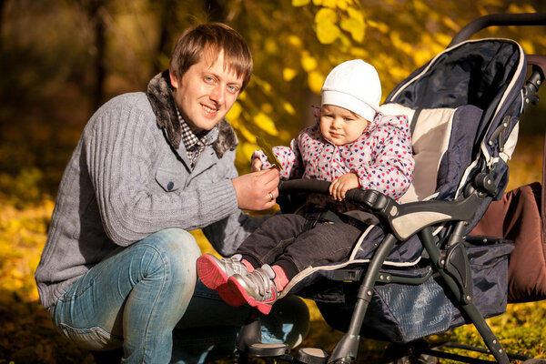 Father and daughter in buggy at autumn park