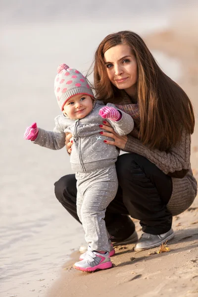 Matka se baví s malou dcerou na břehu řeky — Stock fotografie