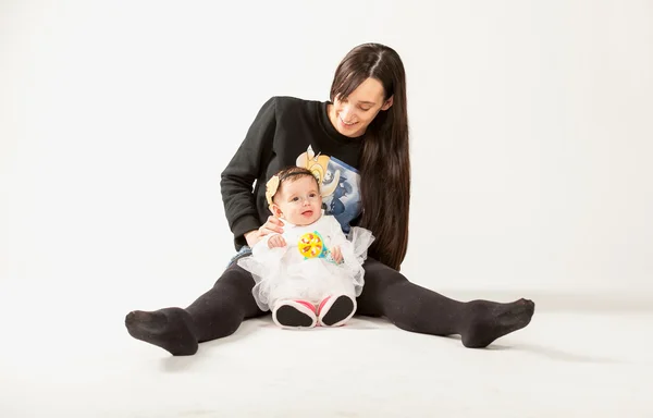 Matka sedí na podlaze ve studiu s dítětem — Stock fotografie