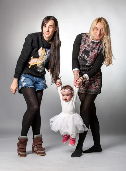 Mãe e filha adulta balançando pequeno bebê — Fotografia de Stock