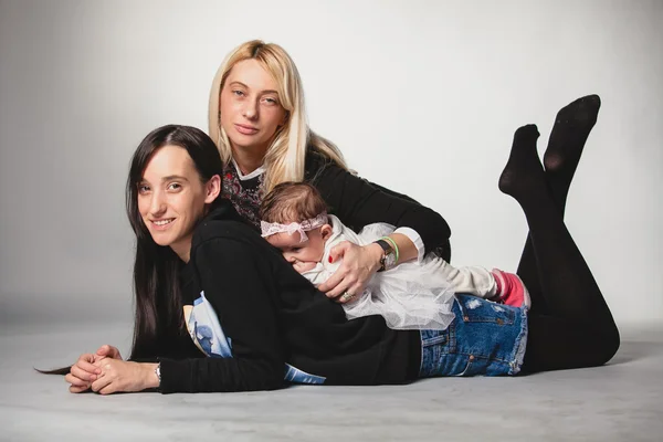 Mother with little and adult daughter lying on floor — Stock Photo, Image