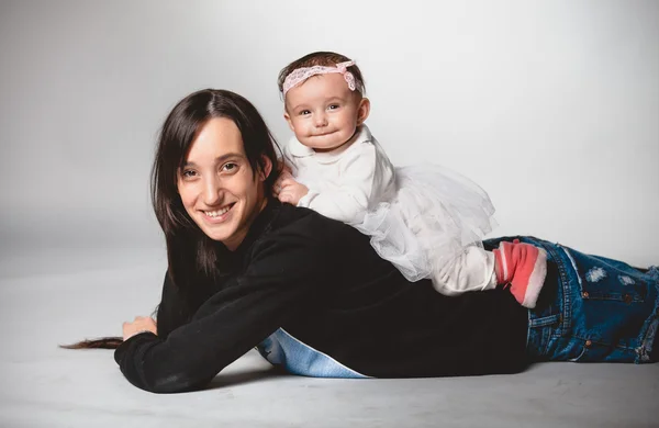 Hijita acostada sobre madres en el estudio —  Fotos de Stock