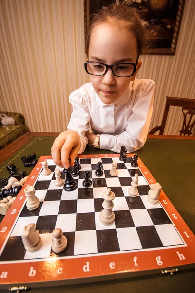 Portrait of girl in eyeglasses playing chess — Stock Photo, Image