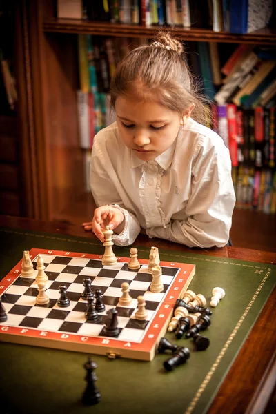 Menina fazendo movimento no tabuleiro de xadrez — Fotografia de Stock