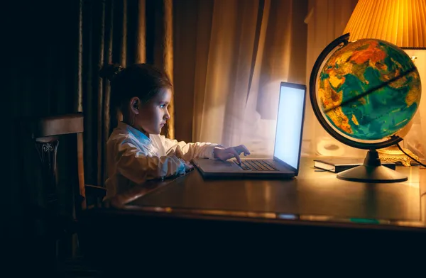 Menina fazendo lição de casa no laptop à noite — Fotografia de Stock