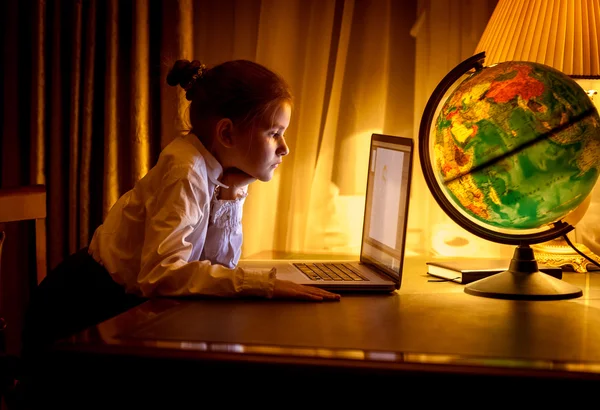 Menina olhando para a tela do laptop no quarto escuro — Fotografia de Stock