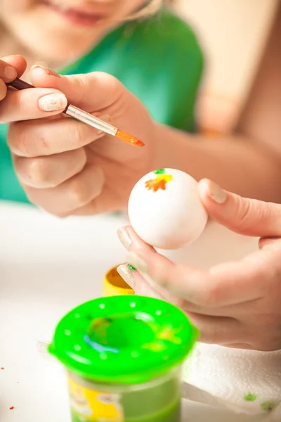 Woman and girl drawing flowers on easter eggs — Stock Photo, Image