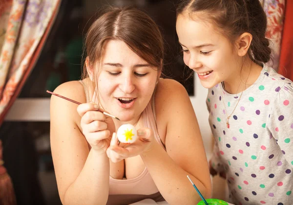 Портрет матери и девочки, рисующие пасхальные яйца — стоковое фото