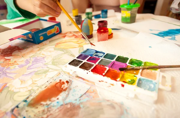 Little girl holding brush and taking watercolor — Stock Photo, Image