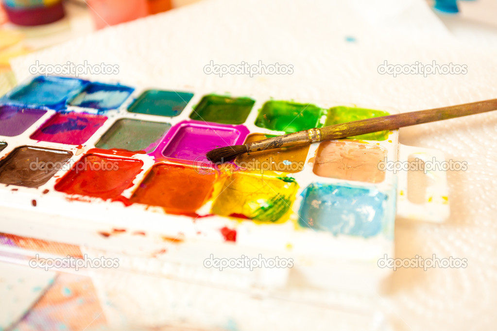 Photo of palette with watercolors and brush