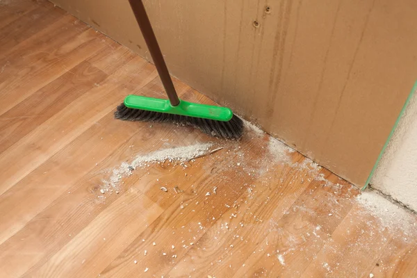 Rengöring skräp på golvet med borste — Stockfoto