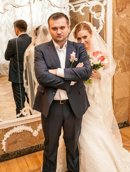 Mooie bruid permanent achter bruidegoms terug — Stockfoto