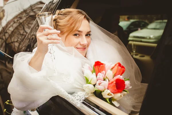 Blonde Braut schaut aus dem Limousinenfenster — Stockfoto