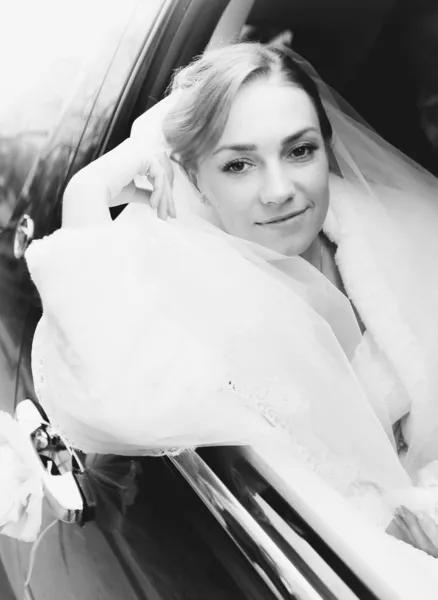 Beautiful bride looking out of car — Stock Photo, Image