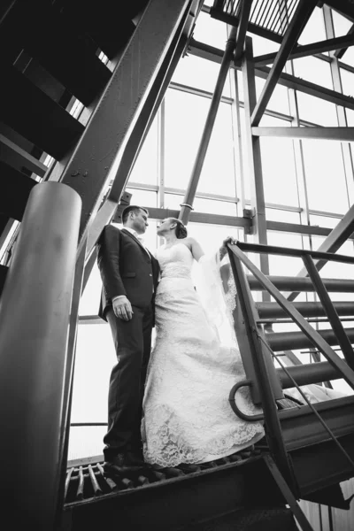 Casamento casal de pé nas escadas debaixo do telhado — Fotografia de Stock