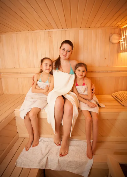Woman with little girls relaxing at finnish sauna — Stock Photo, Image