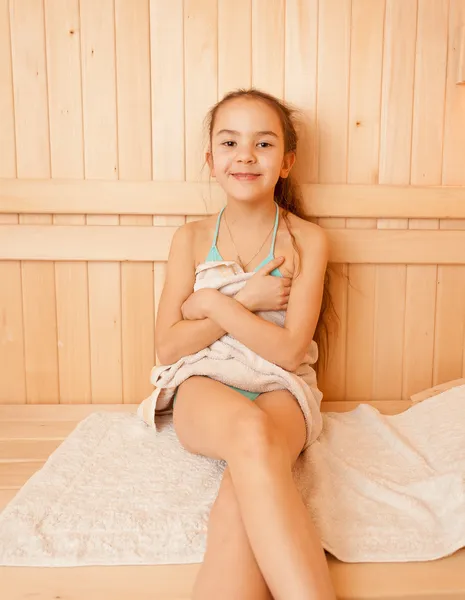 Smiling little girl sitting on bench at sauna — Stock Photo, Image