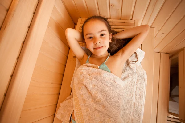 Portrait of little girl lying at sauna — Stock Photo, Image