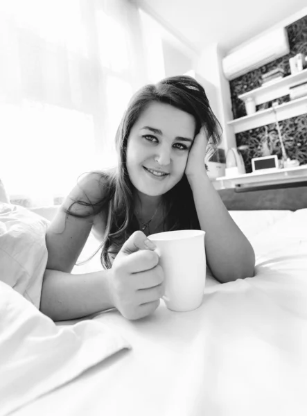 Mujer sonriente bebiendo café en la cama —  Fotos de Stock