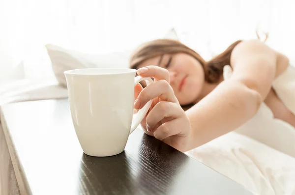 Piękna kobieta przy filiżance kawy w łóżku — Stok fotoğraf