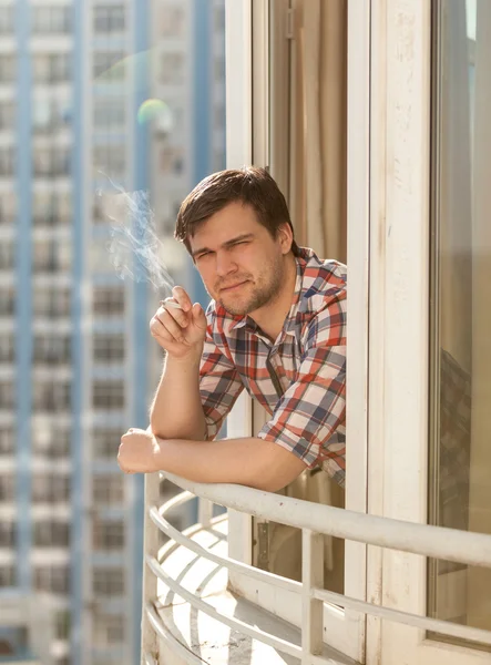 Jovem fumando cigarro na varanda — Fotografia de Stock