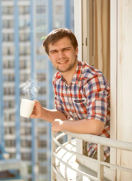 Porträtt av man dricka kaffe på balkongen — Stockfoto