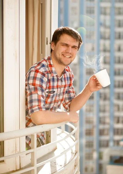 Hombre positivo beber café en el balcón por la mañana —  Fotos de Stock