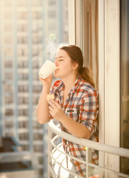 Žena pije kávu a jíst souboru cookie na balkóně — Stock fotografie