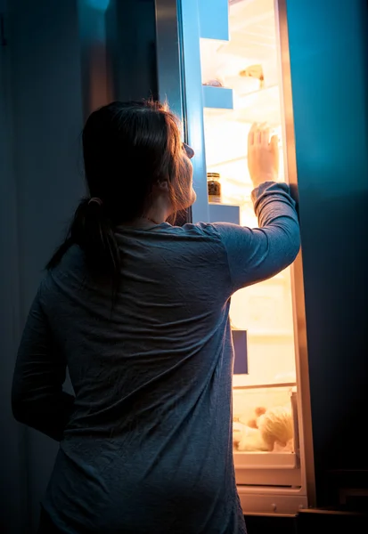 Wanita muda membuka kulkas di malam hari — Stok Foto