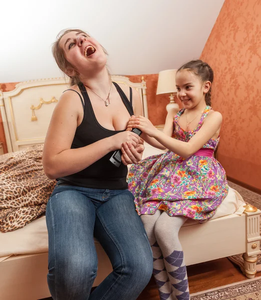 Older and little sister having fight for TV remote — Stock Photo, Image