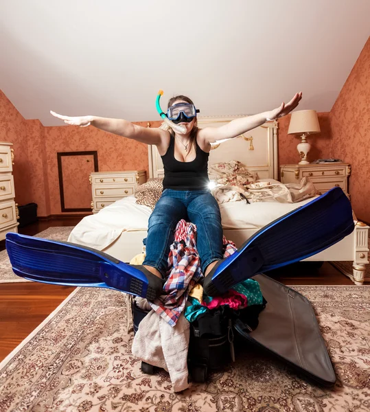 Woman in snorkeling equipment sitting on bed — Stock Photo, Image