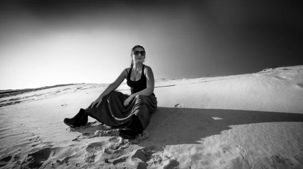 Photo of tired woman sitting on sand dune — Stock Photo, Image