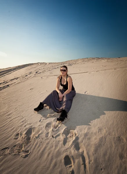 Mulher de vestido sentado na duna de areia — Fotografia de Stock