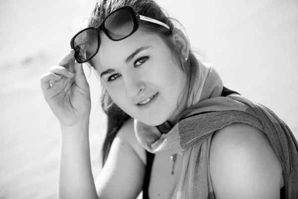 Portrait of woman in desert holding sunglasses — Stock Photo, Image