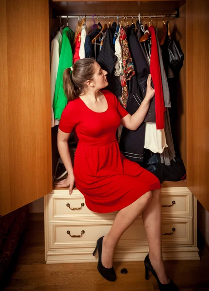 Frau entscheidet, welche Kleidungsstücke sie im Kleiderschrank trägt — Stockfoto