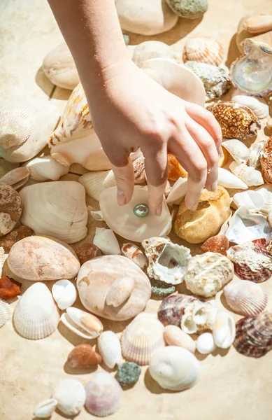 Hand picking black pearl from sea bottom — Stock Photo, Image