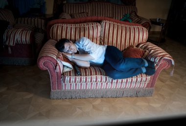 tv yakınında gece kanepede uyuyan adam