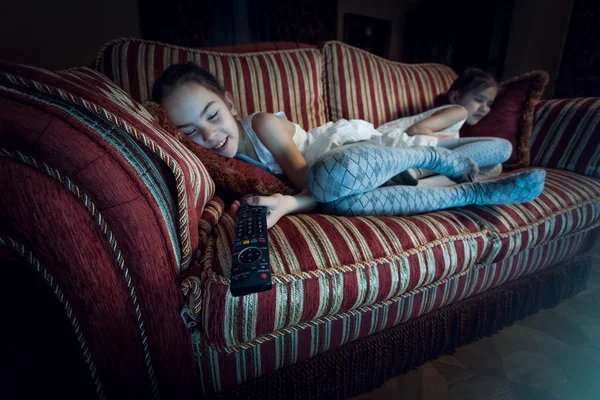 Two girls fell asleep on sofa while watching TV — Stock Photo, Image