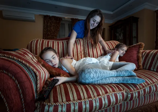 Mother waking up two daughter fell asleep at night while watchin — Stock Photo, Image