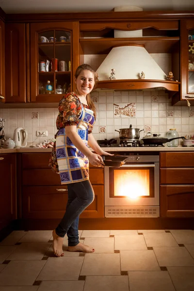 Домохозяйка печет печенье в духовке на кухне в стиле кантри — стоковое фото